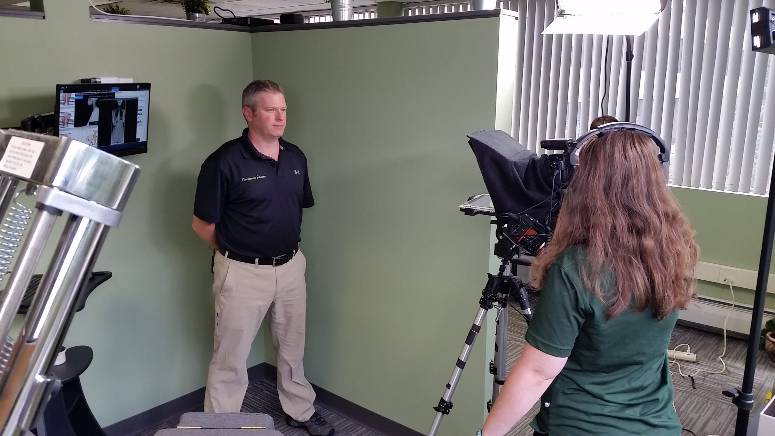 Lead Editor and Creative Director, Candice Moore, using a teleprompter while recording a video with Dr. Chris Hauck of Chiropractic Solutions
